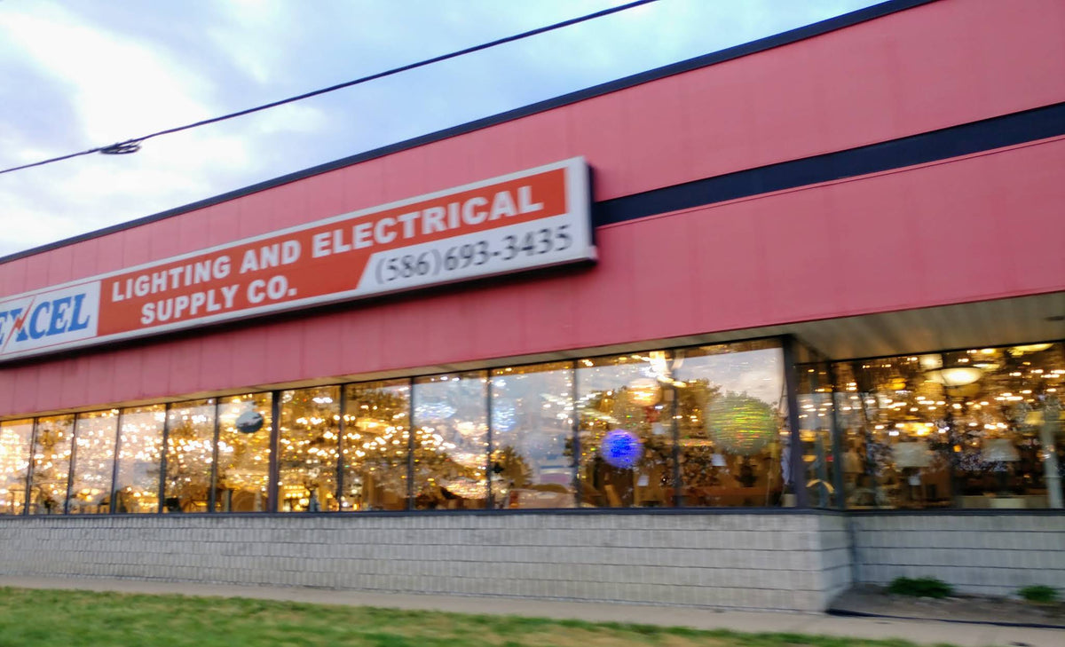 Excel Lighting & Electrical Supply Co. storefront on 8 Mile Road in Warren, with chandeliers lit up in the windows